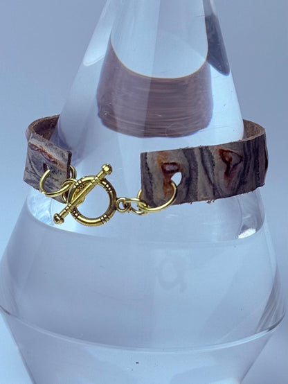 Handgefertigtes geprägtes Lederarmband: Rustikale Boho-Manschette mit goldenem Knebelverschluss